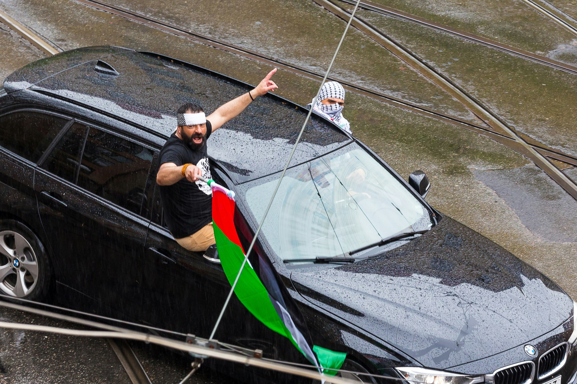Palestinian protestors lean out of their cars