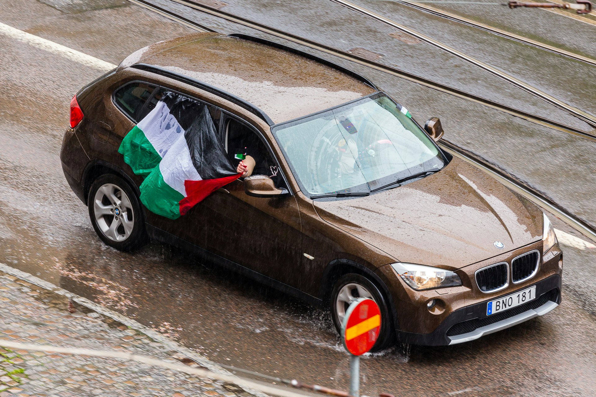 Soaked by the rain, the Palestinian flag flys flat on the car