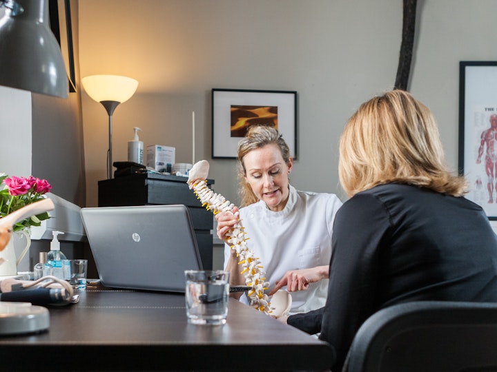 Amy Beeton Osteopath explains the mechanics of the spine to her client.