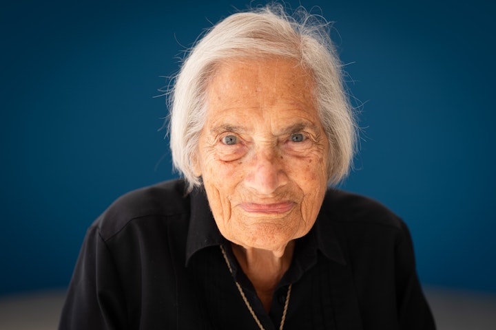 Open Britain: Portrait of a Diverse Nation - Hannah Elsa Shamash was born in Berlin in 1927, daughter of a pioneering radiologist. She remembers Kristallnacht, 10 November 1938, when Jewish men were rounded up. Her father avoided arrest by riding the underground for three days. On 2 March 1939, Elsa and her brother Heinz were sent via Holland on the Kindertransport to London, sponsored by an uncle. Separated into boarding schools, they often cried themselves to sleep. In April, their parents joined them with £1 and a wedding ring. Life slowly improved despite war and hardship. Elsa thrived at school in Cambridge, joined the Girl Guides, and studied French and Spanish at Queen Mary College. She became a teacher, married Saleh, and had two children. Forty-seven years later, she returned to Germany, invited by the mayor of Berlin. Now she volunteers with refugee women, recognising the desperate patterns of displacement, sadly witnessing history repeat itself.