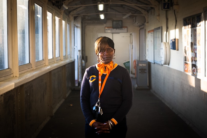 Open Britain: Portrait of a Diverse Nation - Viveth Hardy is ‘The station lady that sings.’ She’s ‘Jamaican born and bred’. She moved here in 2002. Why? ‘It’s a mystery!’ she laughs, she laughs a lot, ‘Wasn’t a choice. Spontaneous. Things happen. You just move to it. I’m a gambler’.
In Jamaica she was mother of four boys (now fully grown and fled the nest) and a machine operator in a kids snack factory. When she moved here, she was a carer for 4 years.
Now she’s busy making commuters smile with her special gift of song. Why does she do it? ‘It warms my heart. It’s something to do with the within. I don’t do it because I want to sing. It’s a spiritual thing. I can’t control it. If it comes, I have to get with it. I don’t have any shame in my game. I be on the platform. I be on the street. I be at home. I just sing. I be sleeping. I wake up in the morning with a song in my head. I just sing. I’m like a Boom-Box’. She’s a Boom Box that’s a bit of a legend in Kensal Rise.