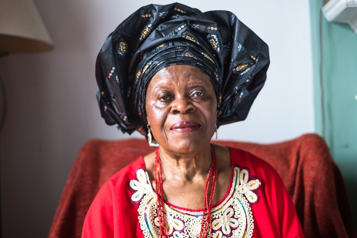 Open Britain: Portrait of a Diverse Nation - Elizabeth Akalawu was born in Imostate, South East Nigeria. Her parents were yam farmers. (see picture). Elizabeth was a talented student. She studied general nursing and midwifery after school in Nigeria. She planned to come to the UK for two years but sixty years later she’s still here. It wasn’t an easy start though, she used to cry from homesickness.
From an early age she always wanted to look after and help people. So, the choice of nursing was an easy one. She had planned to teach midwifery, but when she arrived ‘they laughed at me’. Although trained by Irish nurses to European standards in Nigeria, they wanted her to redo her studies here. Elizabeth is a strong character, she pushed back. They then said she needed to do learn the cultural difference. Elizabeth didn’t have an answer for that. She negotiated it down to one year.
In the 80’s as a school nurse in Brent she discovered black parents were fearful of going to parents’ evenings and disadvantaged children were suffering. So, ‘Nurse Liz’ went on home visits to persuade the parents to attend. It worked. School nurses across Brent then followed suit. A new era began.
Elizabeth spent fifty-four years balancing being a mum and being a nurse. She loved being a midwife but admits she had bigger ambitions. Something that was neither helped by having four children nor coming from abroad.
Elizabeth is glad that things are easier for her children’s and grandchildren’s generations. She counts introducing home visits to schools in Brent as one of her greatest achievements. I can’t help thinking fifty-four years’ work for the National Health Service is pretty good too