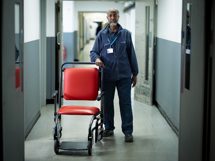 Open Britain x NHS Imperial Trust Collaboration - Omar Moalem – porter, Charing Cross
Omar Moalem is from Mogadishu, Somalia. He used to be a farmer growing goat feed and vegetables, but then in 1999 the war came and he and his wife had to flee.
Omar’s wife is a cleaner at Hammersmith Hospital. Omar was a stay-at-home dad to seven children before looking for a job. The NHS has English Language proficiency requirements that international healthcare workers need to pass before being able to progress so the first step was to improve his English Omar has now been a porter at the Trust for two years and is responsible for moving patients and equipment around the hospital.