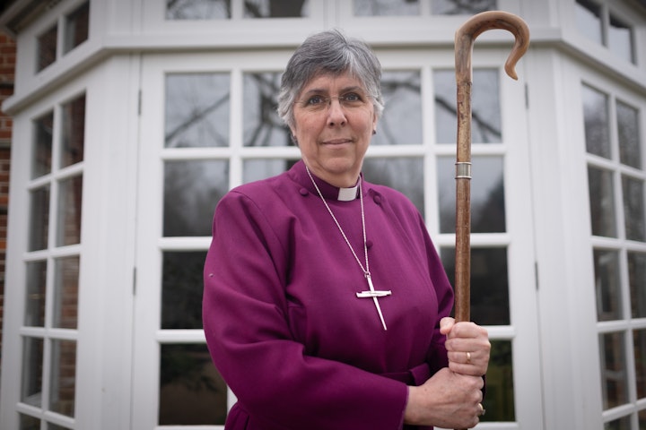 Open Britain: Portrait of a Diverse Nation - Bishop Guli Francis-Dehqani was born in Isfahan, Iran, in 1966. Her father, Hassan, from a devout Muslim family, chose Christianity at 18 and became a bishop before Guli was born. In post-revolution Iran, their faith brought danger. Guli keeps the bullet-ridden pillowcase from the night gunmen attacked her family, injuring her mother. Her father lived in exile in Cyprus, while Guli, her mother, and siblings stayed behind. After her brother was assassinated, they escaped on the last BA flight from Tehran. Despite refugee trauma, Guli thrived at boarding school, studied music, worked at the BBC, and trained for ordination. She became the first woman from a minority ethnic background ordained as an Anglican bishop in England. Now Bishop of Chelmsford, she sits in Parliament as a Lord Spiritual and administered Holy Communion at the Coronation. The staff she carries, once her father’s, connects her to her heritage and the church in Iran.