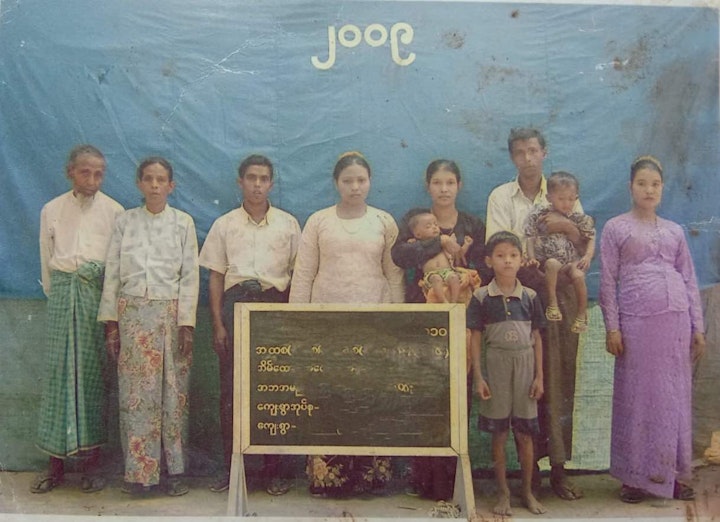 SweTinSit (family audit) of Korim Ullah's family. Korim's grandmother is the central figure in white. She was killed at the river bank. Korim's parents are each holding a child.