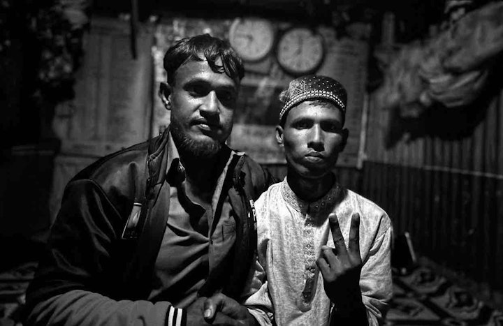 Saddam Hossain sitting with his friend. Image by Mohammed Salim Khan.