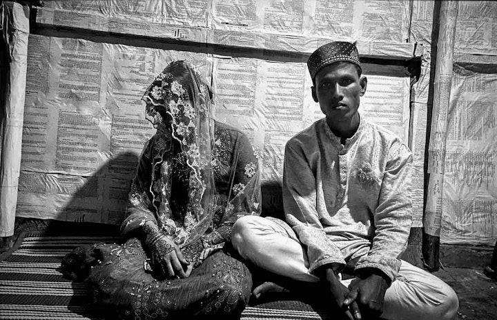 The happy couple sitting together. This posed image was for the purposes of taking a photo. The bride and groom otherwise do not sit together. Image by Mohammed Salim Khan.