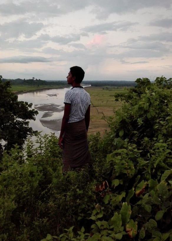 Mohammed Dullah above the stream the villagers crossed to escape