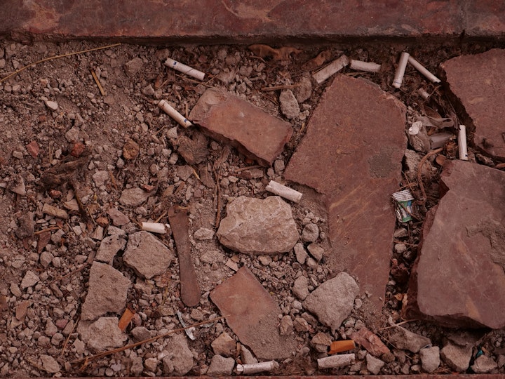 Cigarette butts on the crushed stone steps to the Prijepolje train station's central platform