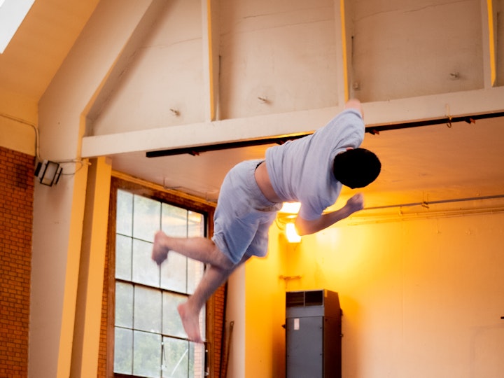 Un étudiant de Master anciennement en spécialité Gymnastique réalise une figure acrobatique devant des étudiants de Licence