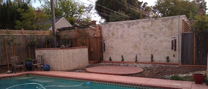 This is how the poppy wall fits into the yard. We hope to add another mural on the large wall to the right, but other projects need to come first.