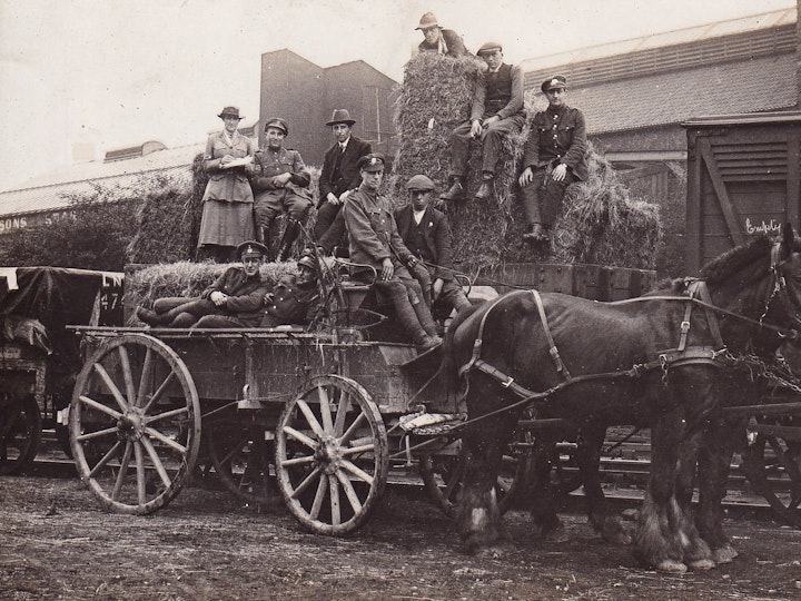 Hay being loaded either onto or off a railway wagon at the sidings at Parnall Factory adjacent to Yate Railway Station and market. Most probably it's local hay that is being sent by train to the war front in France for the war horses.