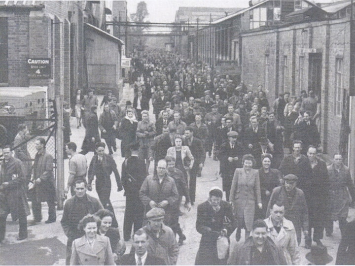 A copy of a photograph of what looks like a Murray Dowding postcard (MD) in a book that Bob helped compile with the Yate & District Oral History Project entitled 'Photographic History of Yate' (2012) of Newman's factory workers leaving work at the end of a shift in the 1950s.