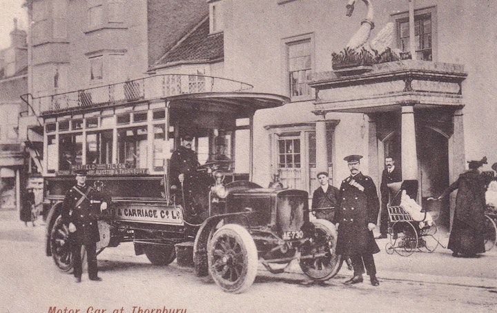 Early bus service by Bristol Tramways & Carriage Co. Ltd. between Horefield in Bristol and Thornbury outside the Swan Hotel in Thornbury in Gloucestershire (A. Prewett, Thornbury). The Swan is Thornbury's original coach houses and one of the oldest buildings in the town after the castle.
Notice the registration number of the vehicle: AE 730. The bus in the following very similar postcard has the registration of AE 731.
In 1887 the Bristol Tramways Company merged with the Bristol Cab Company to form the Bristol Tramways and Carriage Company. The new company developed a fleet of omnibuses to serve the rest of the city and country areas including Thornbury. Note that electric trams were introduced in Bristol in 1895, the first city to do so in the United Kingdom with 237 tramcars covering 17 routes.