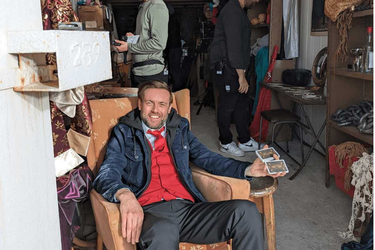 Brendan Patricks between takes on the set of Grace with playing cards