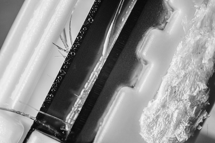 Macro super-closeup of a safety razor with hairs in black and white.