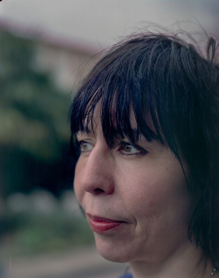 A close portrait of Vicki, sowing her face and cropped fringe in three-quarter view.