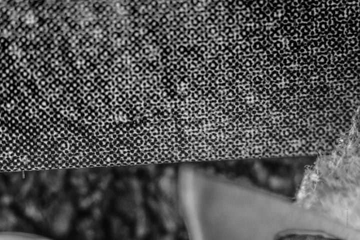 Macro super-closeup of printed halftone on paper in black and white.