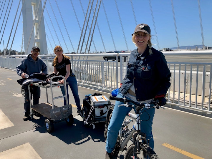 Gaffer Mila Puccini, first AC Kiersten Lane, and Key Asst. Location Manager  Darrick Chan on the Bay Bridge's pedestrian path.  We pulled some of our equipment out to the middle of the bridge via bikes and wagons.