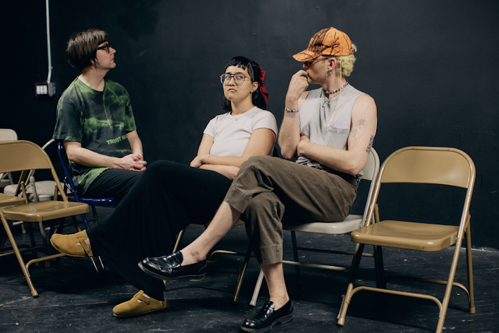 NEXT STOP - Sophia and N.K. (right) in scene as 'the perfect snobs'. Ben  (left) in character as David -practicing looking out the train window. Rehearsals were held every Wednesday evening at Vox Populi from February to April.