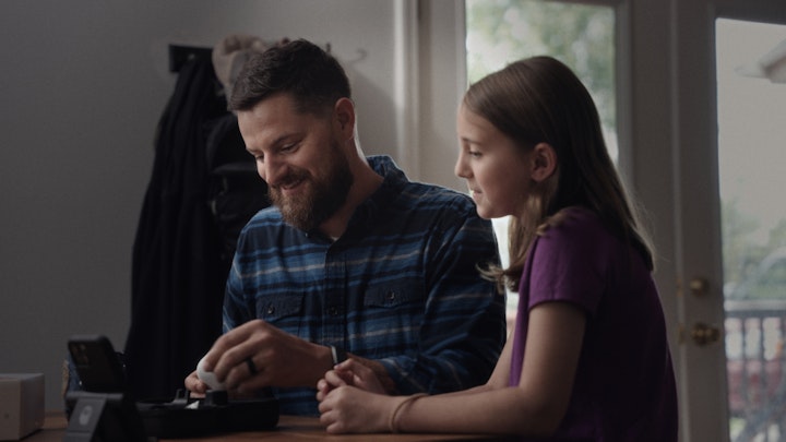 father and daughter smiling medical check up in living room remote care