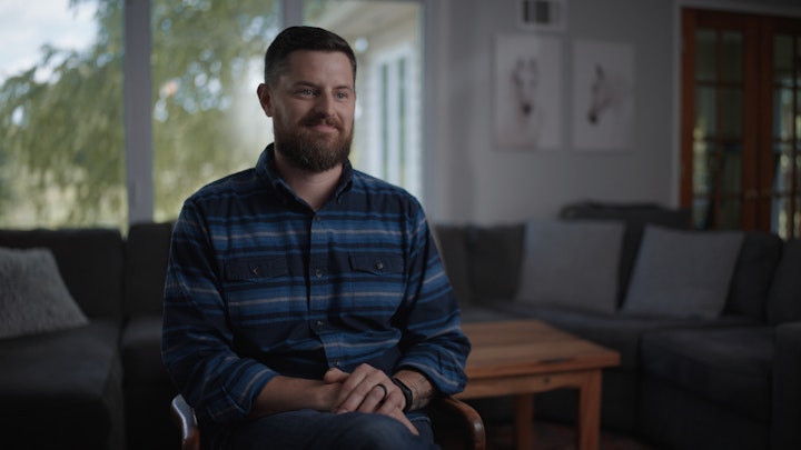 Man sitting in living room for interview smiling beautiful lighting