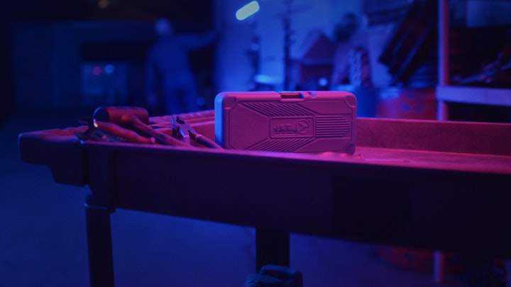 close up of a tool cart in a car garage under neon pink and blue light