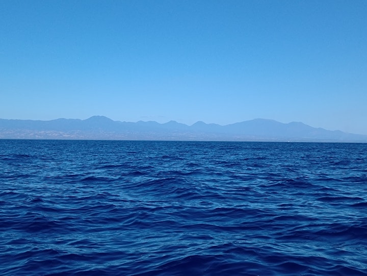 A ridge of hills, volcanoes and mountains is seen from a boat off the coast of western El Salvador. We were looking for whales but all we saw was an amazing view of the ocean and land.
