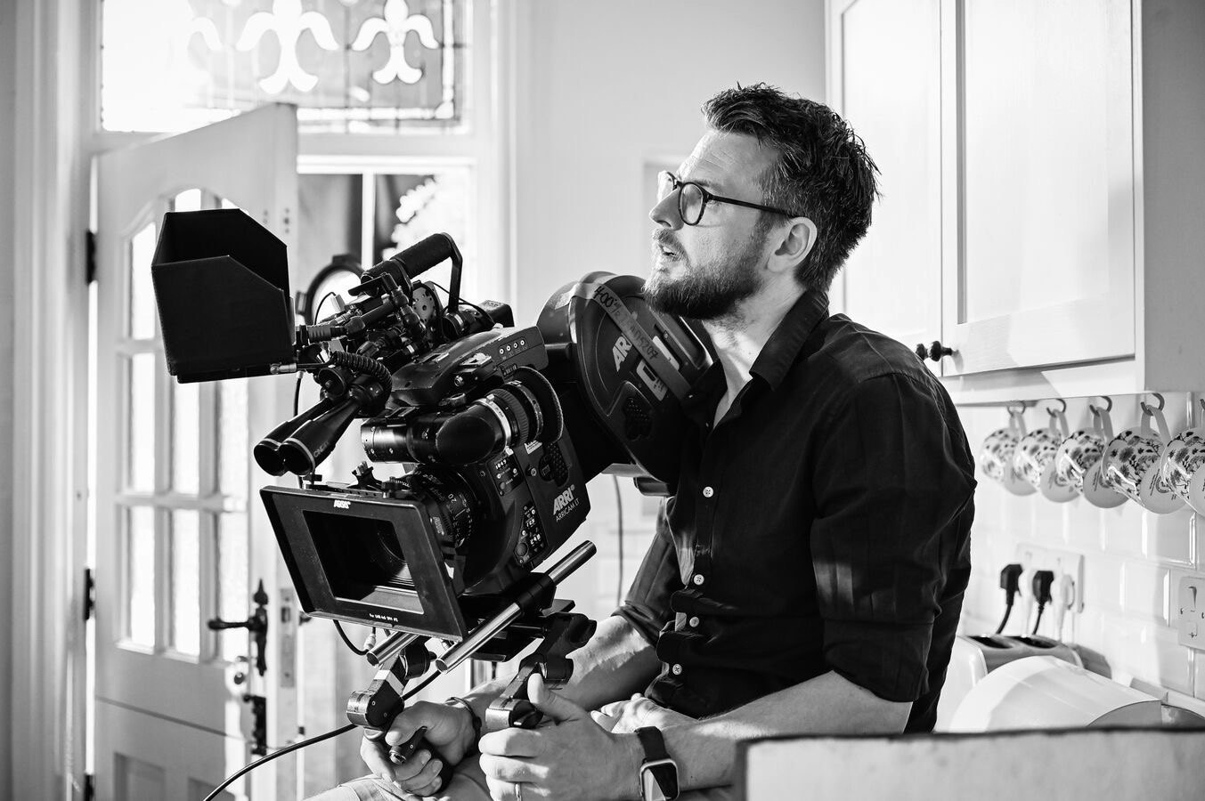 Cinematographer Markus Ilschner operating an ARRI 35mm film camera on set