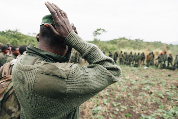 A FARDC soldiers arranges his hat. His platoon is about to enter Virunga searching for FDLR rebels.